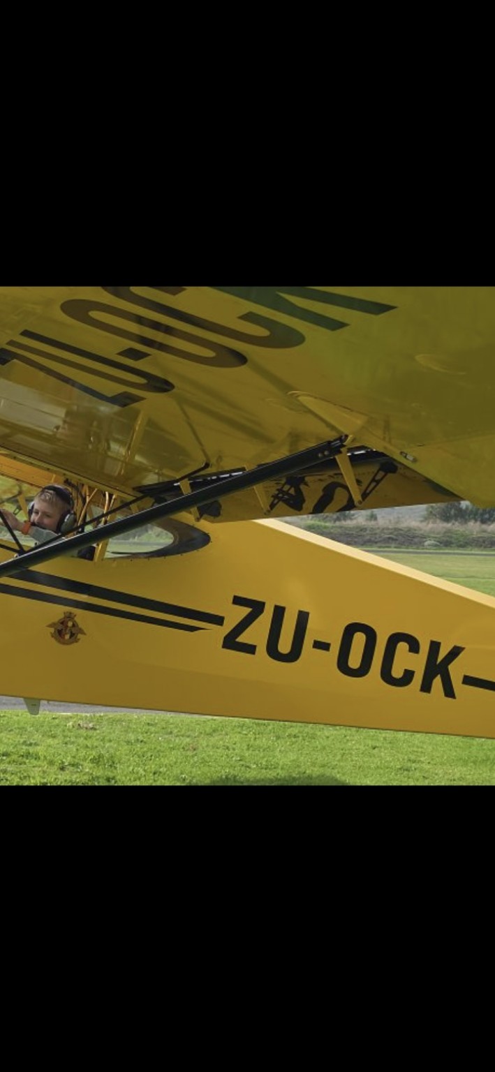 Danny flying in a bright yellow light aircraft
