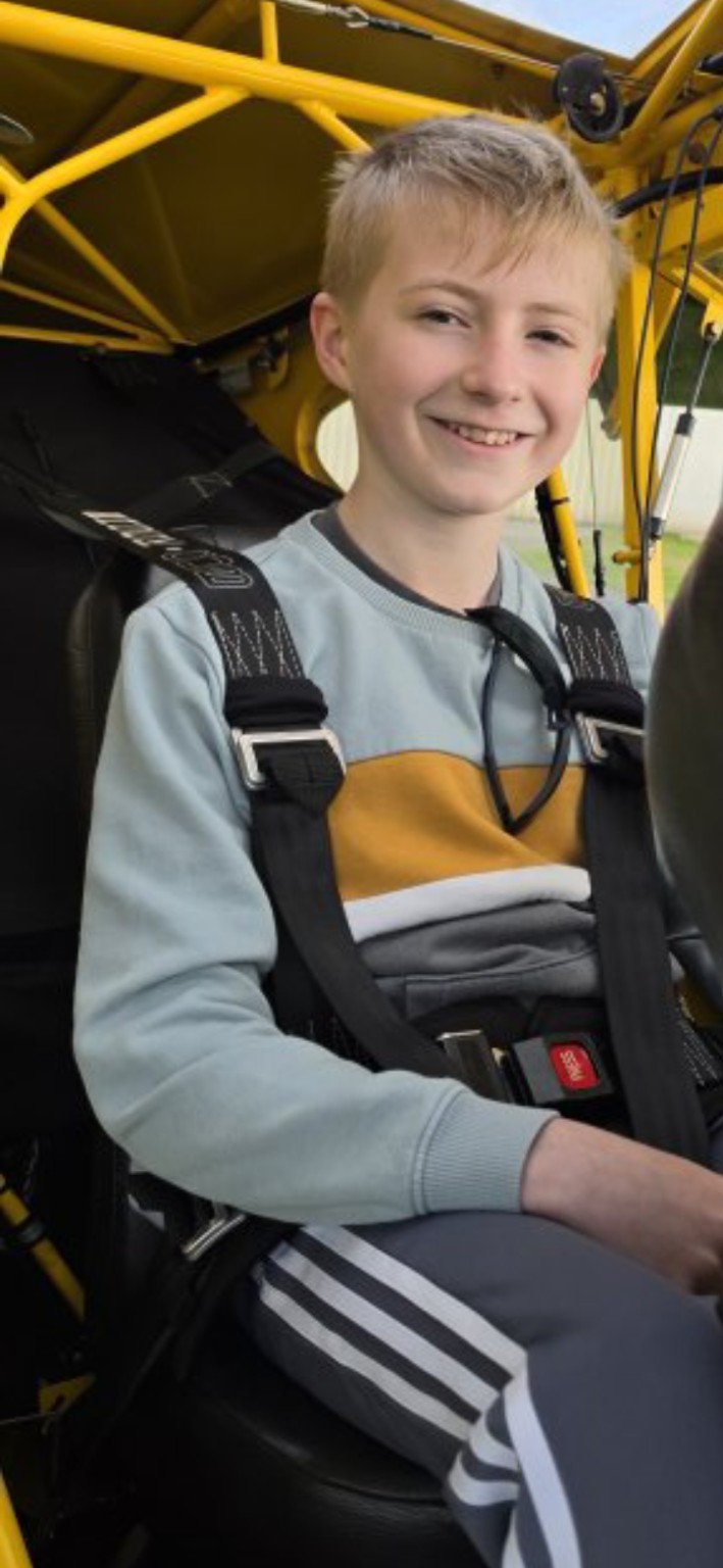 Danny sitting in the cockpit of a yellow aircraft